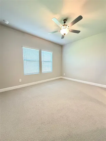 an empty room with a window and a ceiling fan