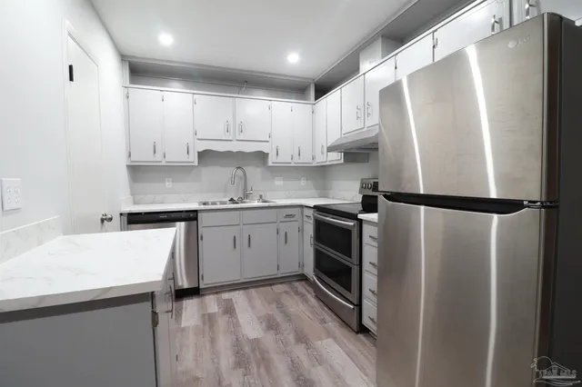 a kitchen with a refrigerator sink and cabinets