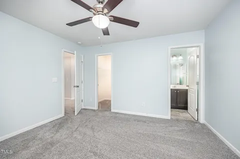 an empty room with windows and ceiling fan