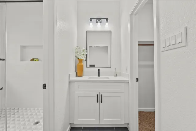 a bathroom with a shower sink and mirror