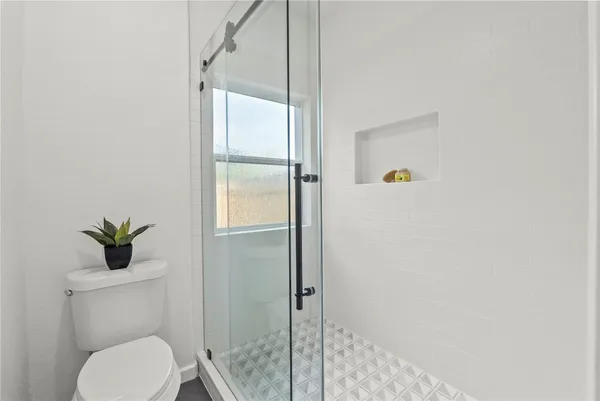 a bathroom with a toilet shower and a sink
