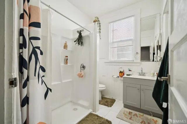 a bathroom with a toilet a sink and mirror