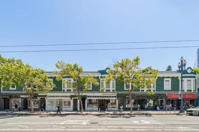 a front view of a building with a garden and plants