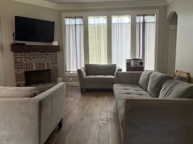 6896 Bethany Reed Circle Blanchard, LA 71107 - Photo 9 of 9 Spacious living area featuring a brick fireplace with a wood-beam mantel, wood-finish flooring, and multiple windows with window treatments