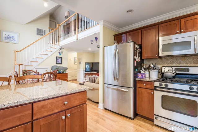 a kitchen with granite countertop a refrigerator stove and sink