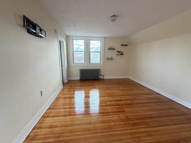 wooden floor in an empty room with a window