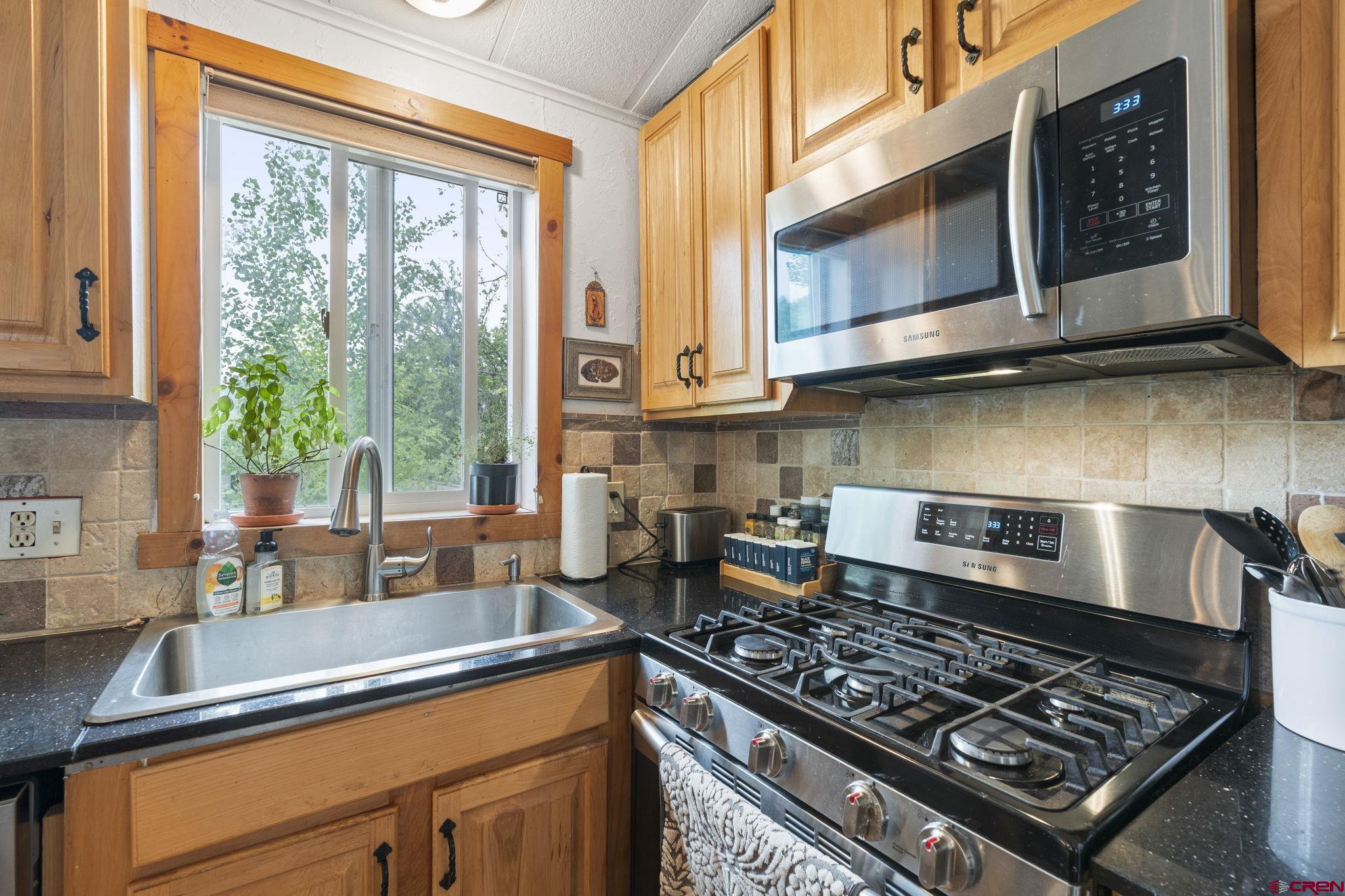 288 Animas View Drive, Unit 87 Durango, CO 81301 - Photo 11 of 27 a kitchen with stainless steel appliances granite countertop a sink a stove and microwave