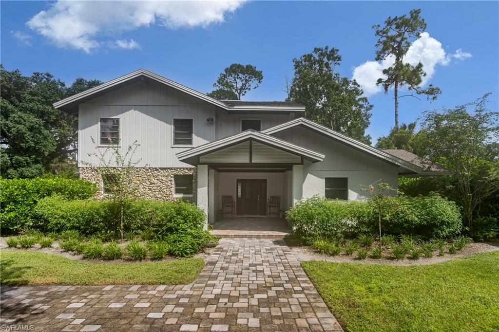 3301 31st Avenue Southwest Naples, FL 34117 - Photo 1 of 28 a front view of a house with a yard