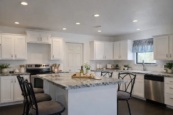 a kitchen with a sink a stove a table and chairs
