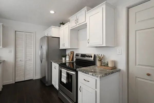 a kitchen with stainless steel appliances granite countertop a stove a refrigerator and a cabinets