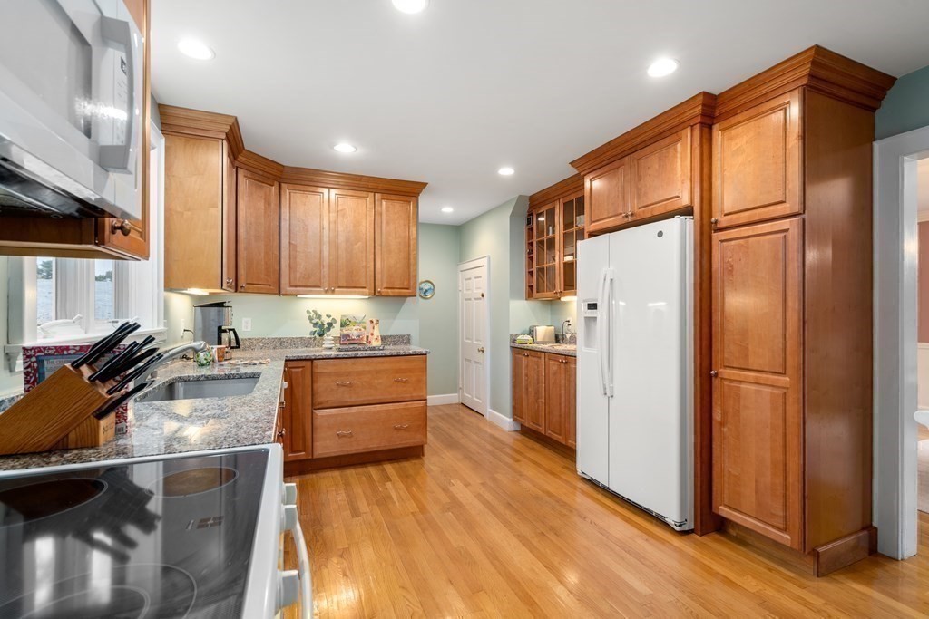 243 Rutledge Road Belmont, MA 02478 - Photo 14 of 21 a kitchen with a refrigerator a stove top oven a counter space and wooden floor