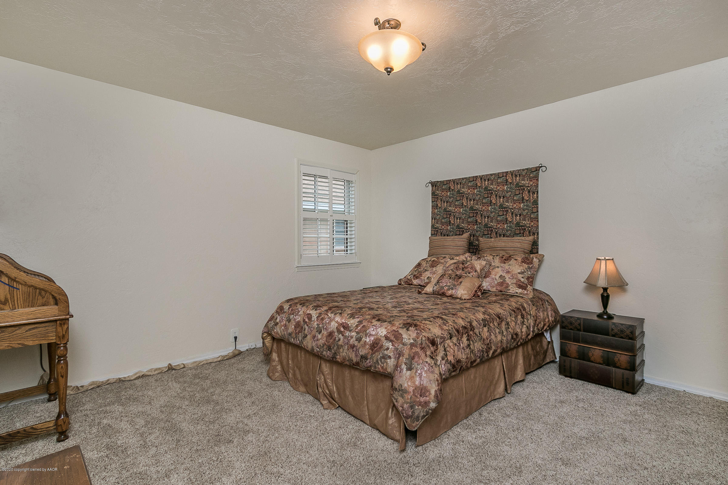 6906 Elmhurst Road Amarillo, TX 79106 - Photo 19 of 33 a bedroom with a bed and a chandelier