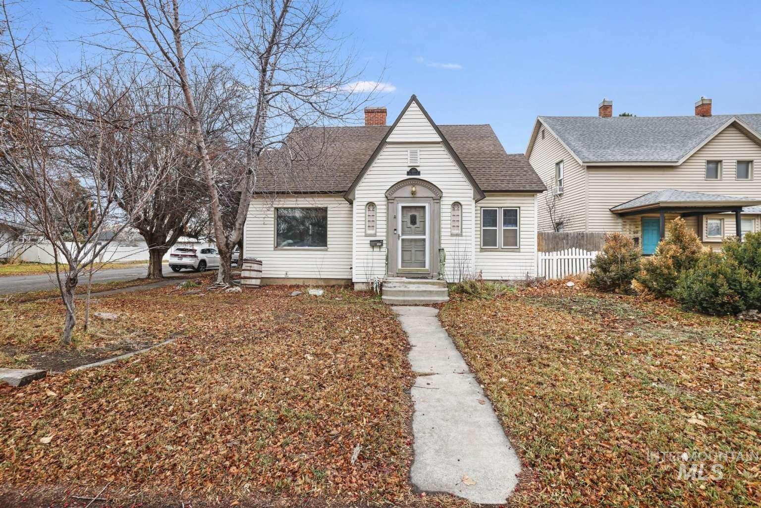 View of front of property with roof with shingles and a chimney