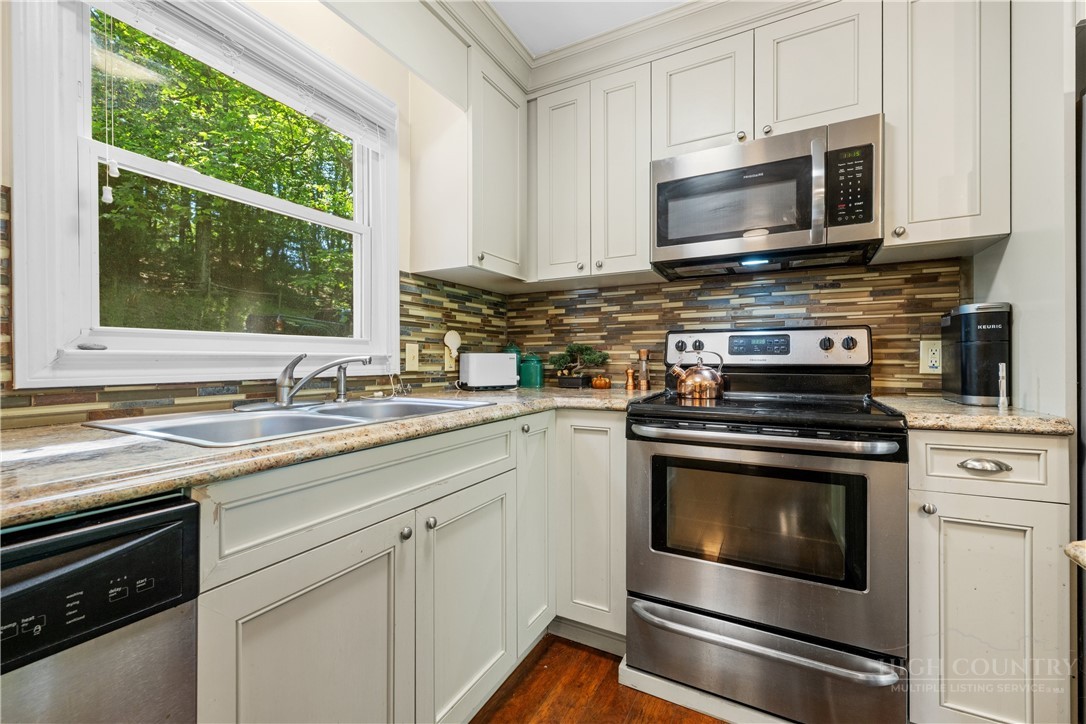 467 Horseshoe Ridge Road East Deep Gap, NC 28618 - Photo 17 of 46 a kitchen with granite countertop a stove microwave and sink