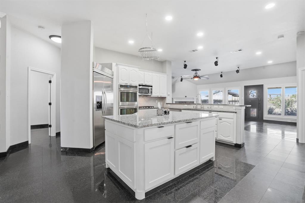 12701 Beech Tree Lane Fort Worth, TX 76040 - Photo 33 of 33 a kitchen with kitchen island white cabinets and refrigerator