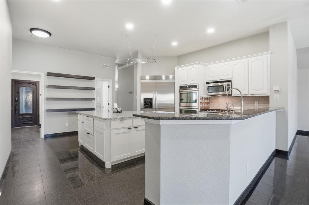 12701 Beech Tree Lane Fort Worth, TX 76040 - Photo 20 of 33 a kitchen with stainless steel appliances cabinets and a kitchen island