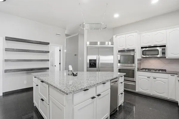 a kitchen with stainless steel appliances cabinets and a kitchen island