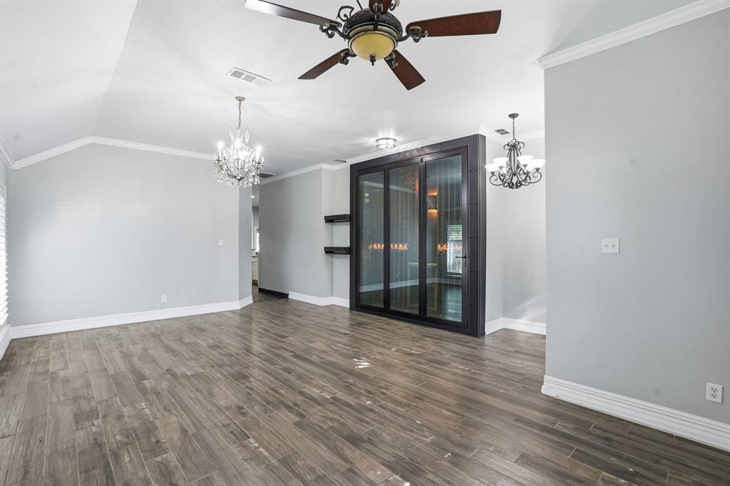 12701 Beech Tree Lane Fort Worth, TX 76040 - Photo 6 of 33 a view of an empty room with wooden floor and a ceiling fan