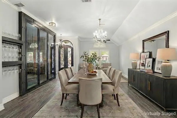 a dining room with furniture a chandelier and wooden floor