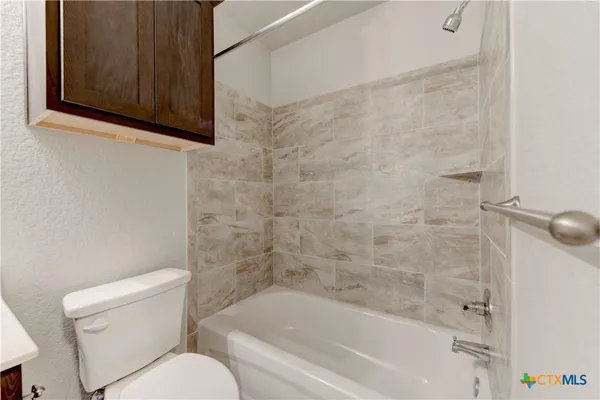 a white bath tub sitting next to a toilet