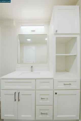 a bathroom with a sink vanity and a mirror