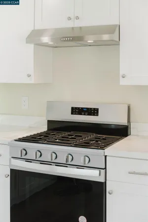 a view of empty room with kitchen and window
