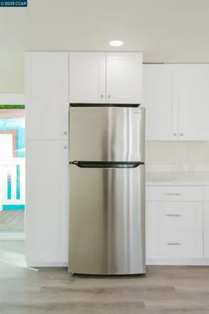 a kitchen with white cabinets and stainless steel appliances