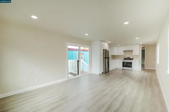 an empty room with a kitchen and a window