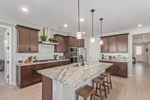 a kitchen with kitchen island granite countertop a sink stove and refrigerator