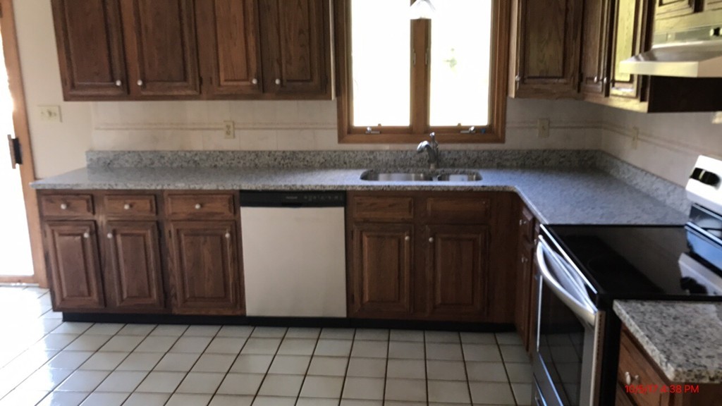 102 Adams Road Grafton, MA 01536 - Photo 12 of 23 a kitchen with granite countertop a stove a sink and a microwave