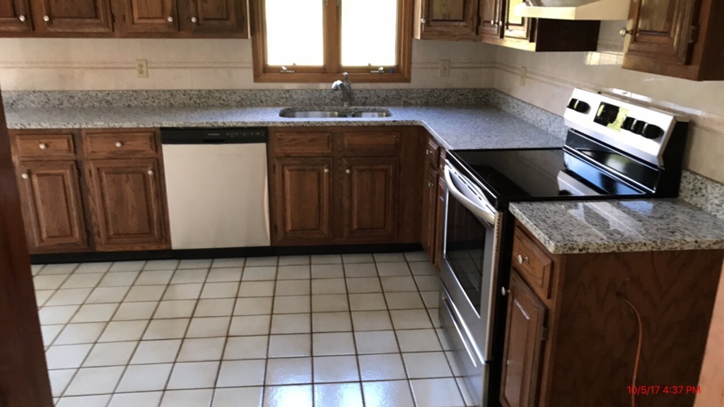 102 Adams Road Grafton, MA 01536 - Photo 7 of 23 a kitchen with granite countertop a stove a sink and a microwave