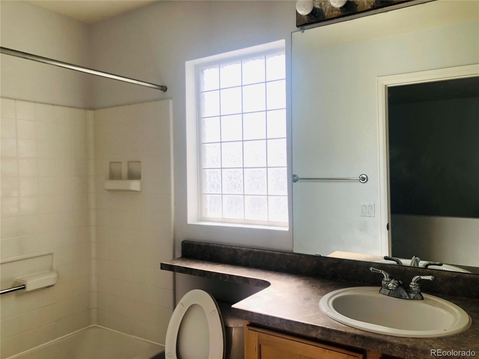 11788 Zenobia Loop Westminster, CO 80031 - Photo 12 of 18 a bathroom with a sink a toilet and a mirror