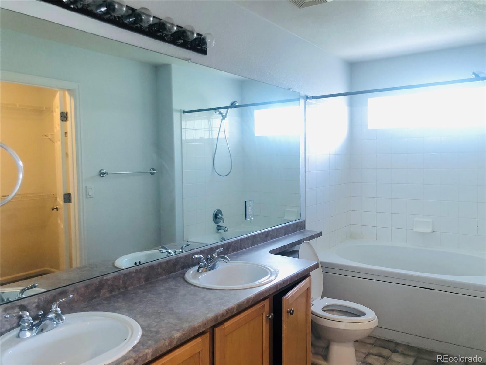 11788 Zenobia Loop Westminster, CO 80031 - Photo 16 of 18 a bathroom with a granite countertop sink toilet and shower