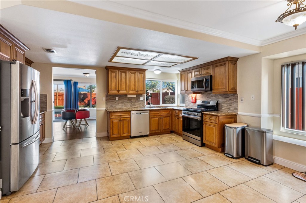 16398 Heather Glen Road Moreno Valley, CA 92551 - Photo 22 of 74 a kitchen with a sink a counter top space stainless steel appliances cabinets and a window
