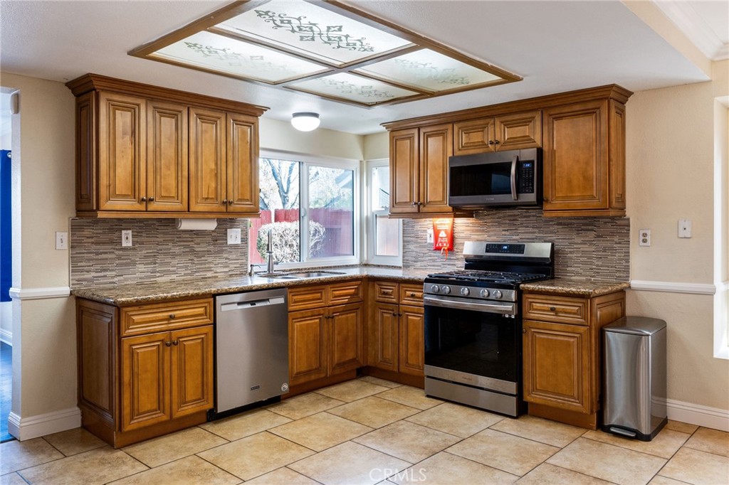 16398 Heather Glen Road Moreno Valley, CA 92551 - Photo 23 of 74 a kitchen with stainless steel appliances granite countertop a stove sink microwave and refrigerator
