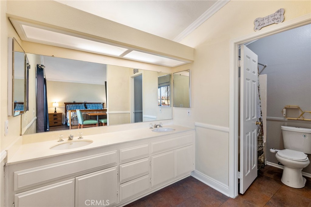 16398 Heather Glen Road Moreno Valley, CA 92551 - Photo 44 of 74 a en suite bathroom with a double vanity sink and mirror