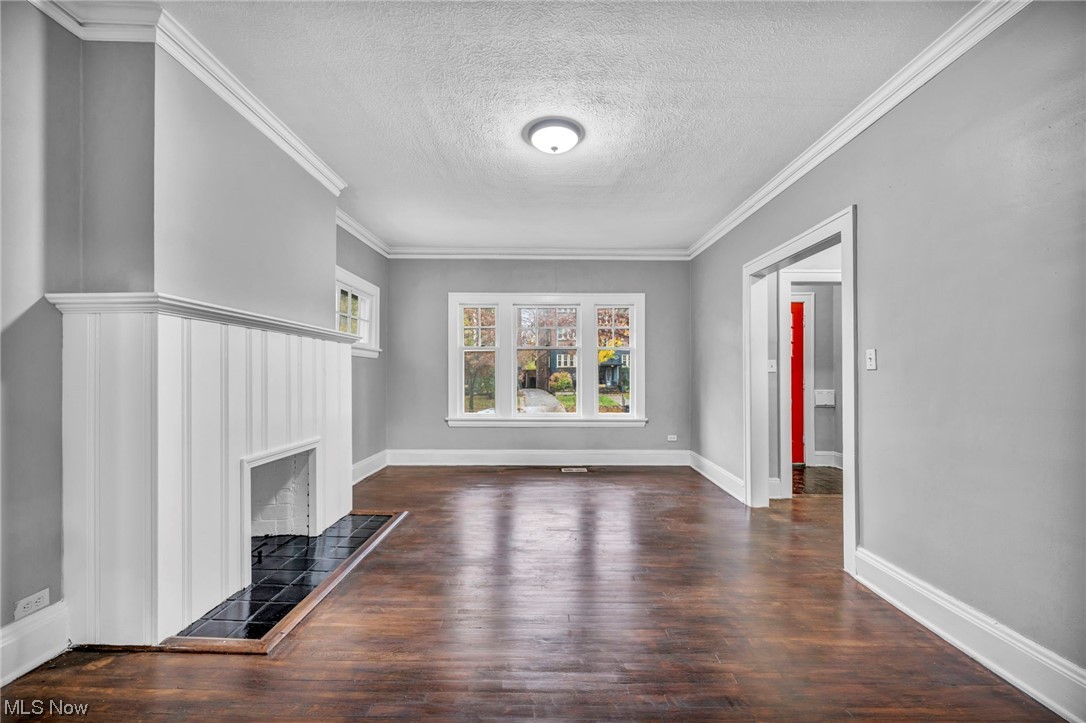 2563 Overlook Road Cleveland, OH 44106 - Photo 16 of 32 Unfurnished living room with dark hardwood / wood-style floors, a textured ceiling, and crown molding