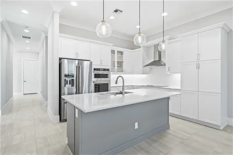 a kitchen with stainless steel appliances granite countertop a refrigerator a sink and a refrigerator