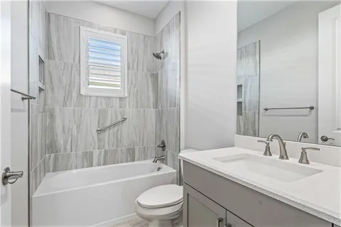 a bathroom with a granite countertop toilet a sink and a bathtub