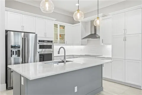 a kitchen with stainless steel appliances granite countertop a sink a refrigerator and a stove