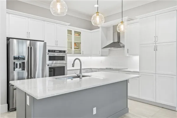 a kitchen with stainless steel appliances granite countertop a sink a refrigerator and a stove