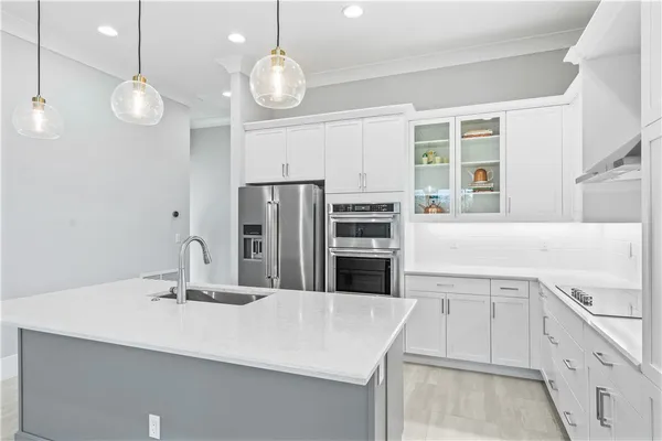 a kitchen with a sink stainless steel appliances a large counter and cabinets