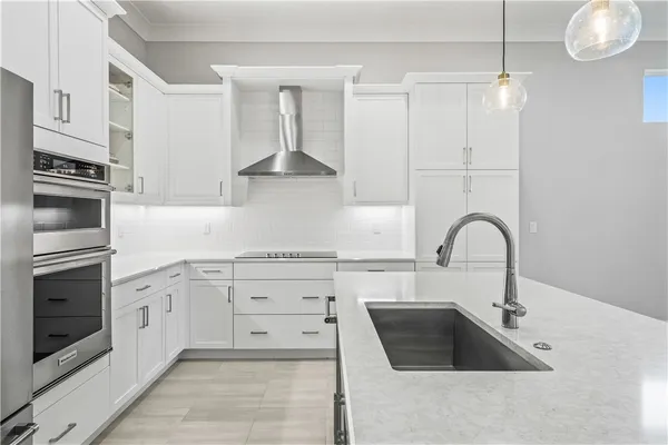 a kitchen with white cabinets a sink and a stove