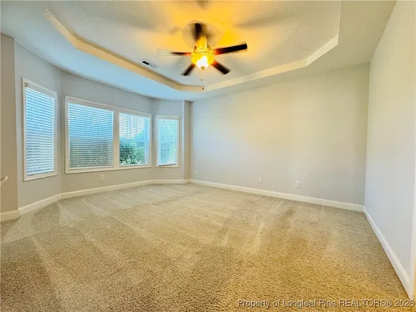 an empty room with a ceiling fan and window