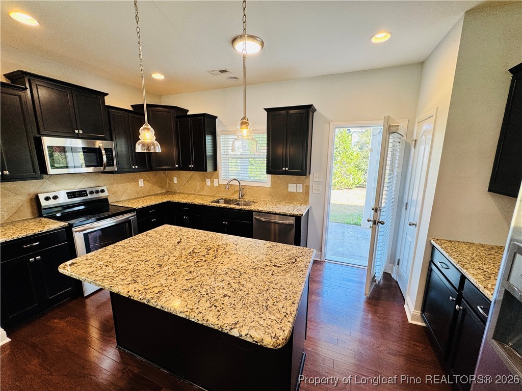 66 Timber Skip Drive Spring Lake, NC 28390 - Photo 7 of 26 a kitchen with stainless steel appliances granite countertop a refrigerator a stove top oven a sink dishwasher and wooden cabinets with wooden floor