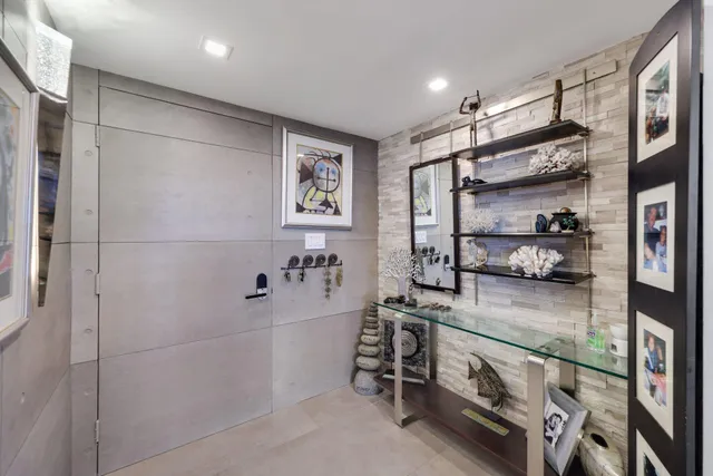 a kitchen with stainless steel appliances kitchen island granite countertop a refrigerator a stove a microwave oven a sink with island chairs and wooden cabinets