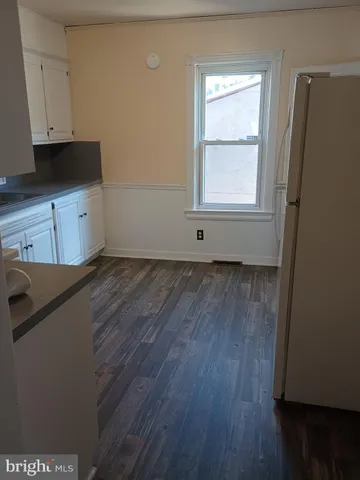 a view of a kitchen with wooden floor and cabinets