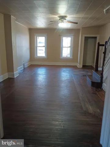 a view of empty room with window and wooden floor