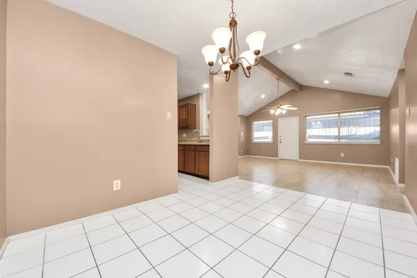 a view of an empty room and a kitchen