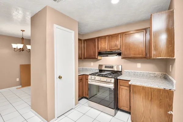 a kitchen with stainless steel appliances granite countertop a stove a sink and a refrigerator